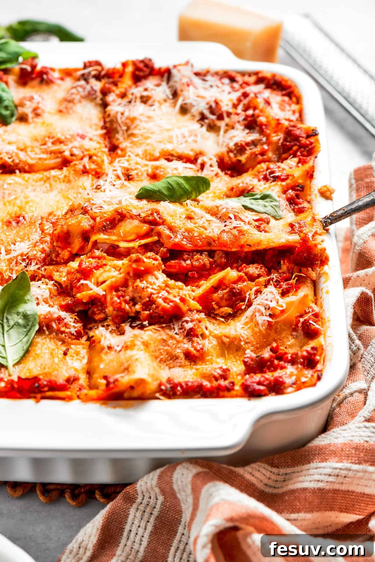 Lifting out a perfect slice of lasagna from a baking dish, showing its delicious layers.
