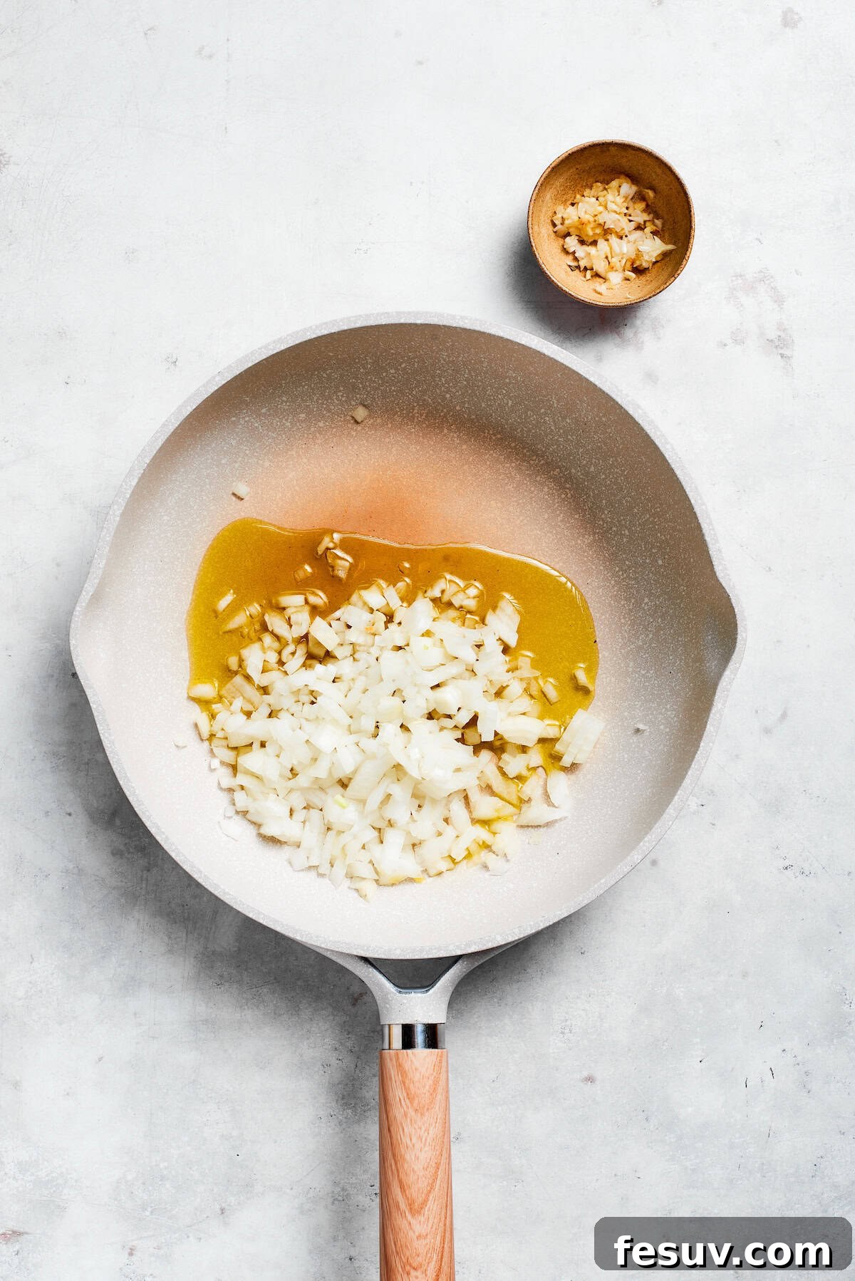 Garlic and onion cook in a skillet, creating an aromatic base for the sauce.