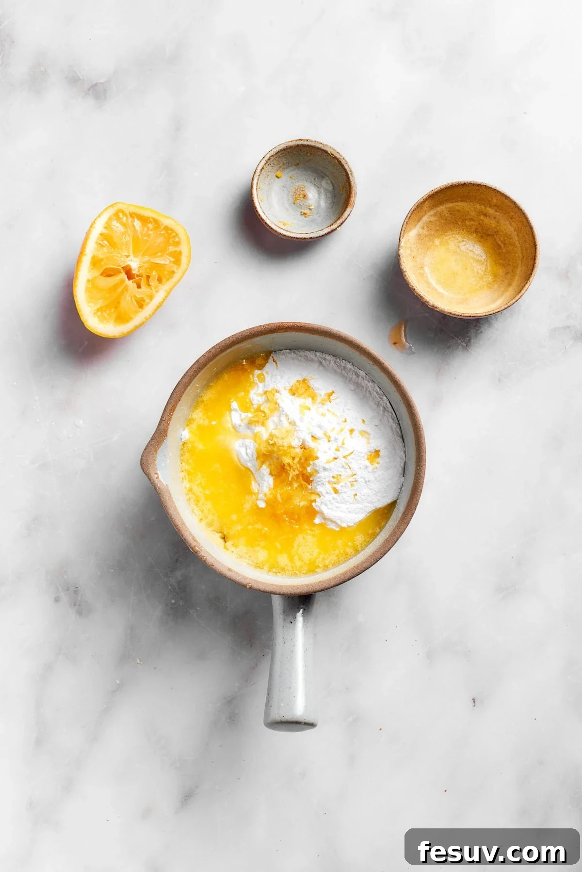 Ingredients for lemon frosting being combined in a mixing bowl.