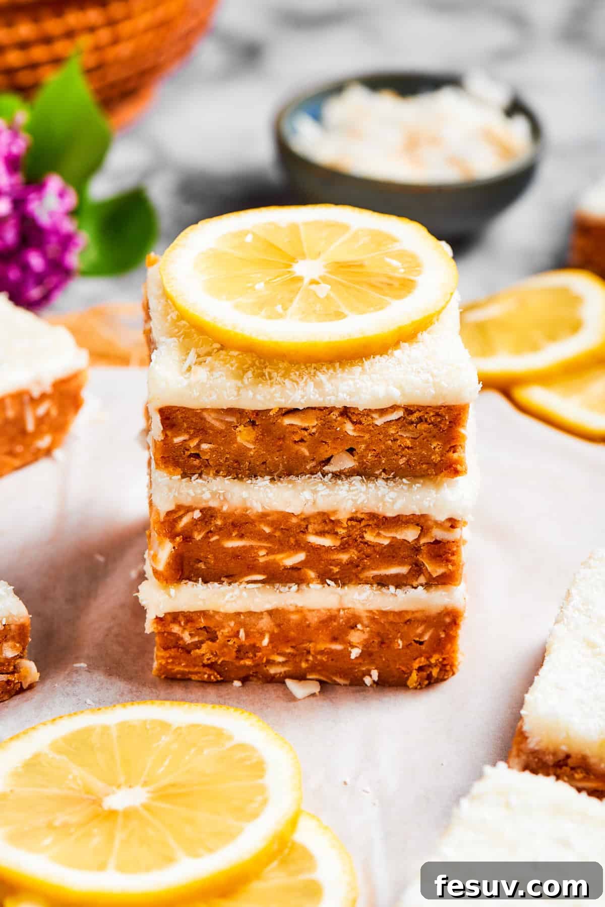 A beautiful stack of lemon slice squares, garnished with a fresh lemon wedge.