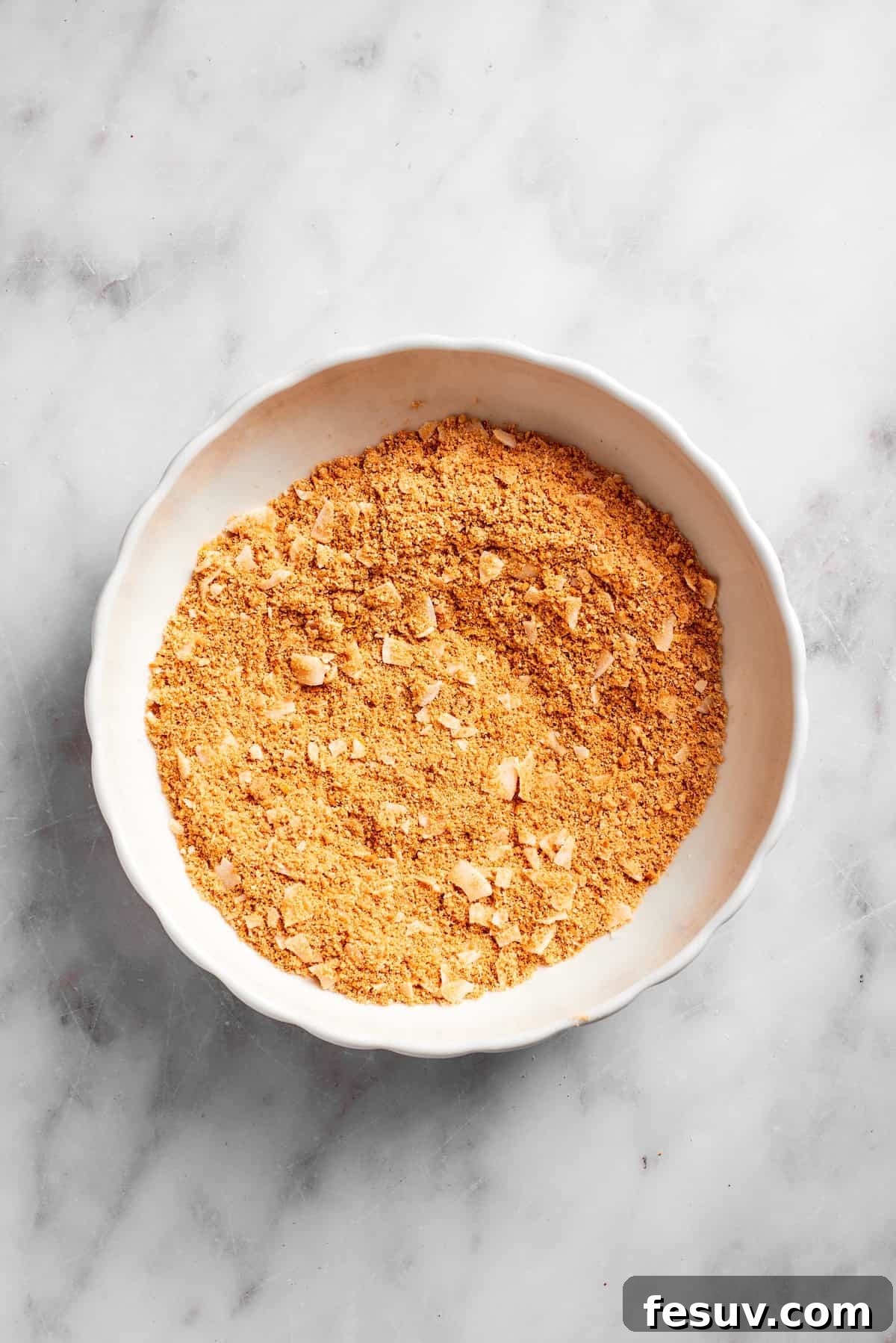 The graham cracker and coconut mixture in a bowl, showing the texture of the base ingredients.