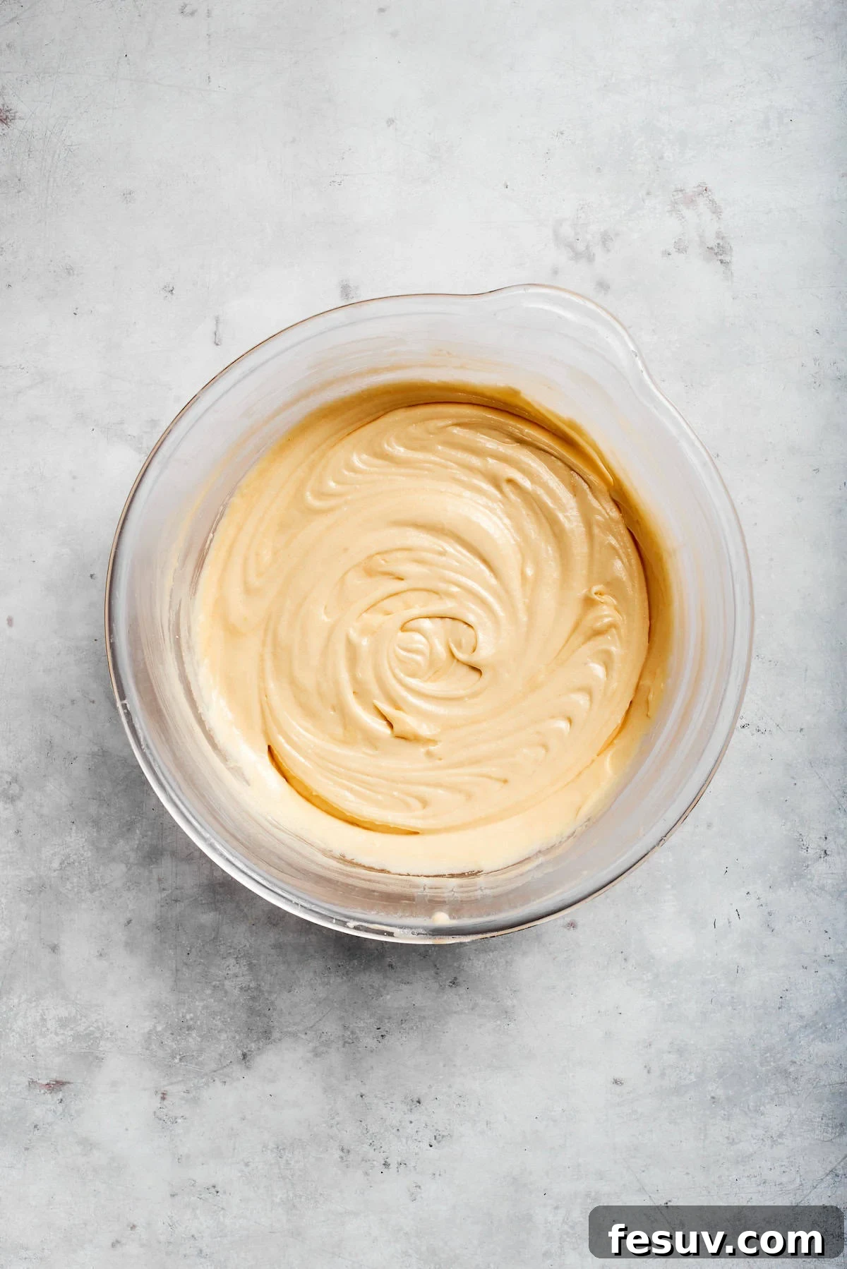The 'Just One More' Cake 11 A bowl of smooth, pale yellow cake batter ready for the next step.