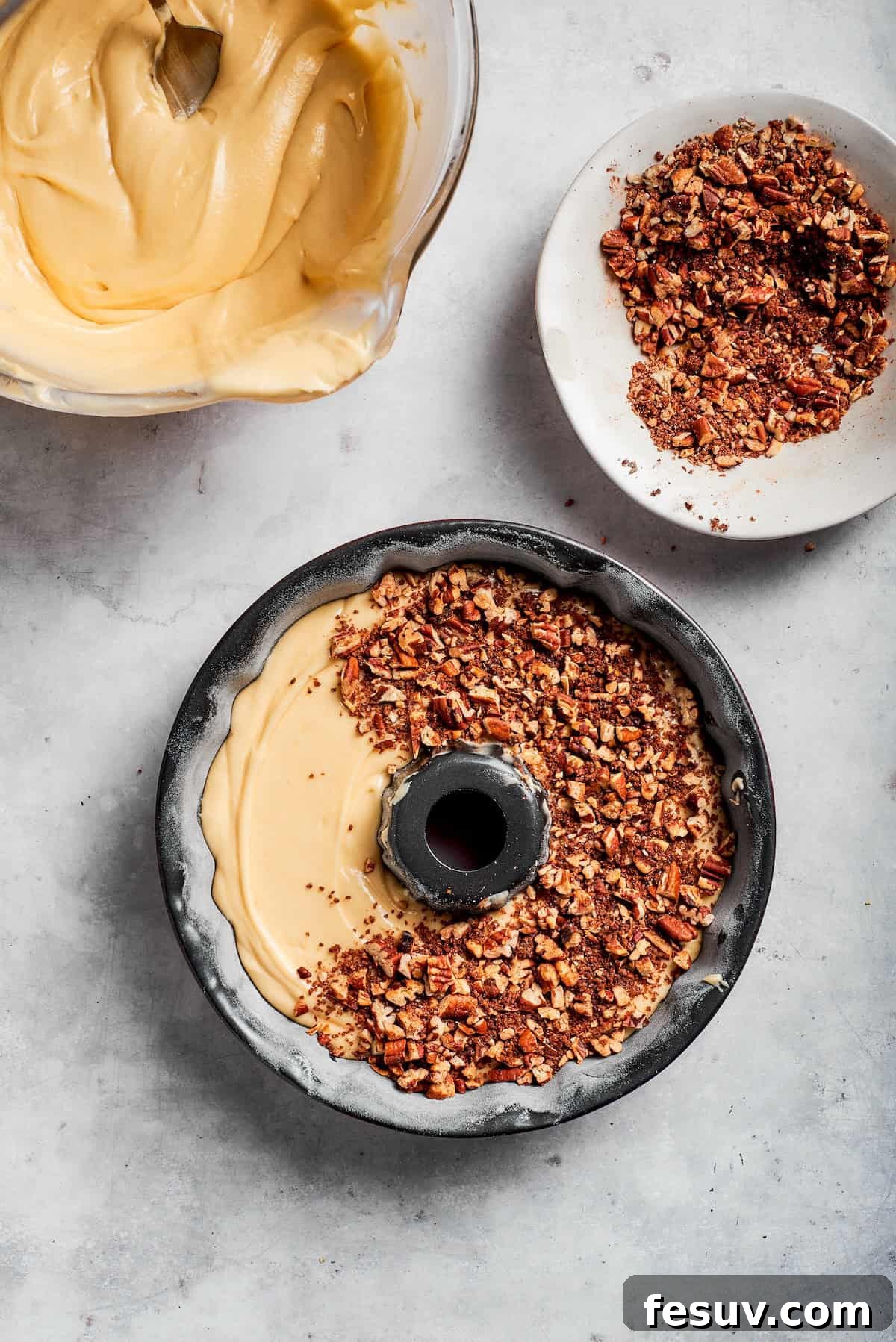 The 'Just One More' Cake 13 The pecan filling being sprinkled evenly over the first layer of cake batter in the Bundt pan.