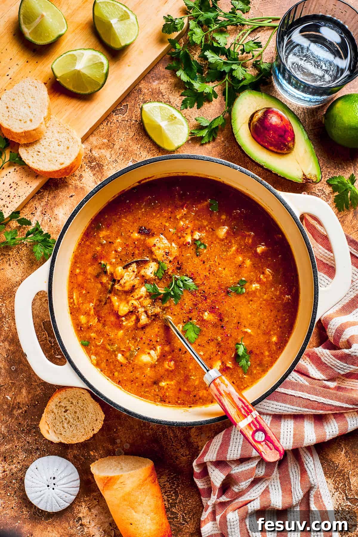 Tender chicken and pinto beans are cooked in a zesty broth made with salsa verde and green chilis to make spicy chicken soup. A pot of spicy chicken soup.