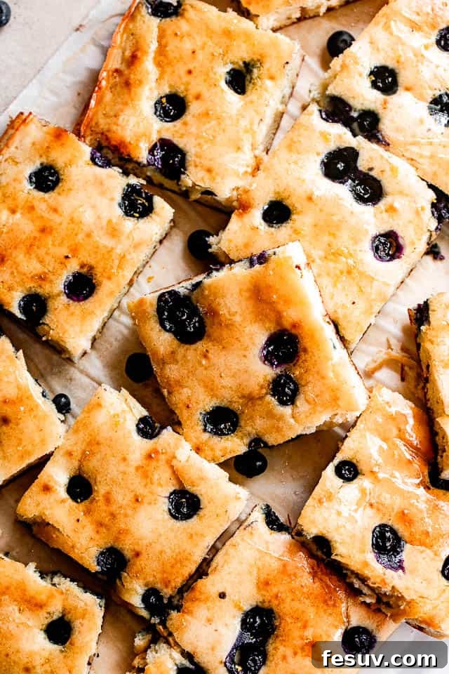 Effortless Sheet Pan Pancakes 4 sheet pan pancakes topped with blueberries and cut into squares