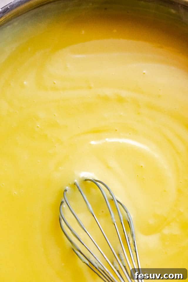 Southern Comfort Banana Pudding 3 whisking homemade vanilla pudding in a saucepan on the stovetop