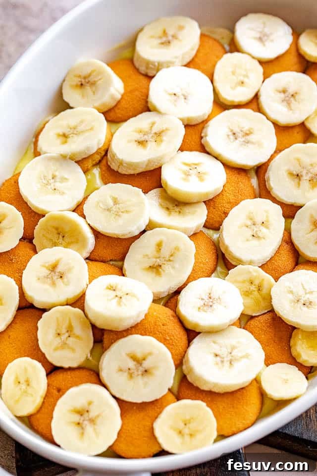 Southern Comfort Banana Pudding 4 layered vanilla wafers and banana slices in a white baking dish before adding pudding