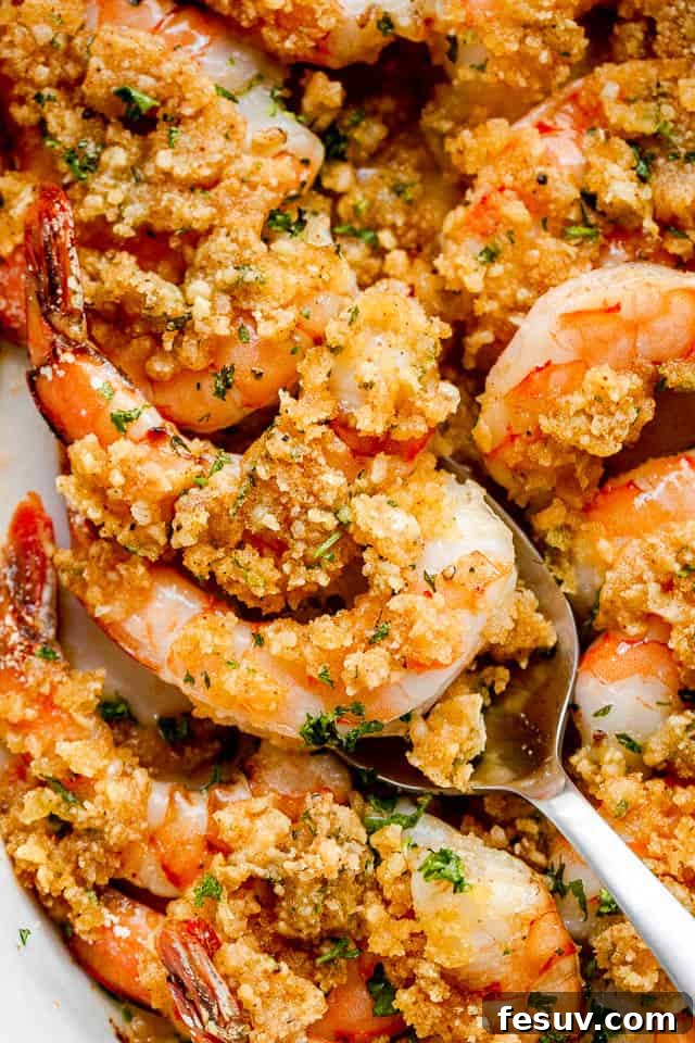 Garlic Butter Baked Shrimp De Jonghe 7 Scooping out Garlic Butter Baked Shrimp with silver spoon.