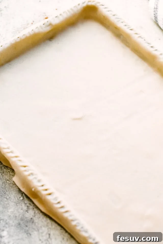 Pie dough skillfully stretched over a sheet pan, ready for filling.