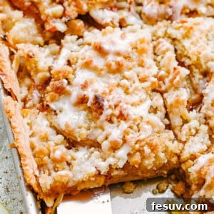 Top shot of a spatula removing a slice of Dutch apple slab pie from a sheet pan.