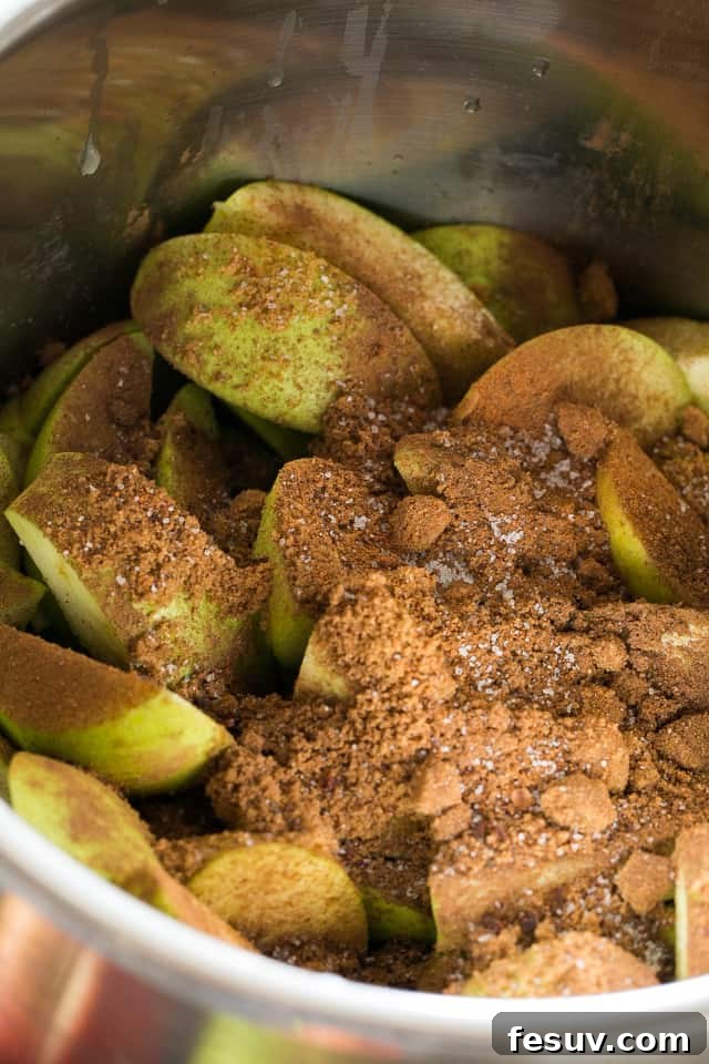 apple wedges in instant pot insert sprinkled with brown sugar and cinnamon