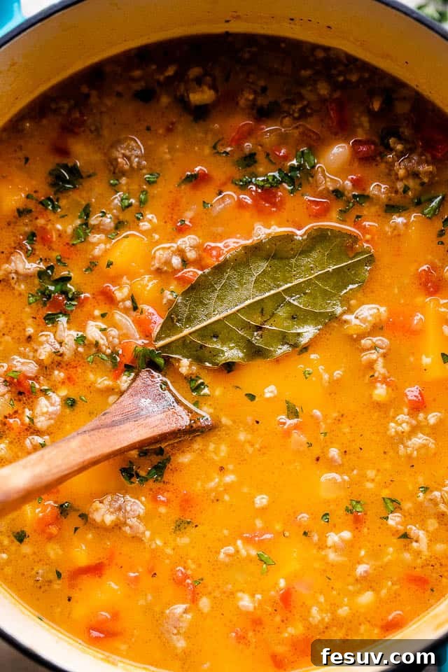 Overhead, close-up image of butternut squash soup cooking in a Dutch oven.