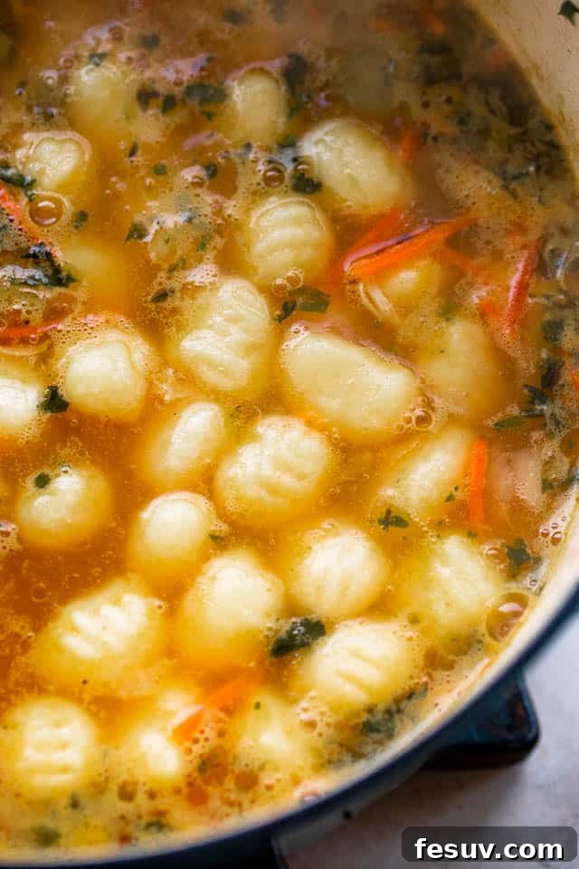 Cozy Creamy Chicken Gnocchi Soup 5 Gnocchi boiling in the creamy chicken soup in a Dutch oven, signaling they are almost ready.