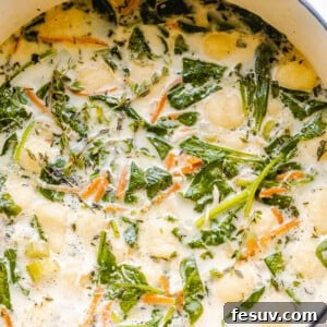 Creamy gnocchi soup with spinach and chicken in a Dutch oven.