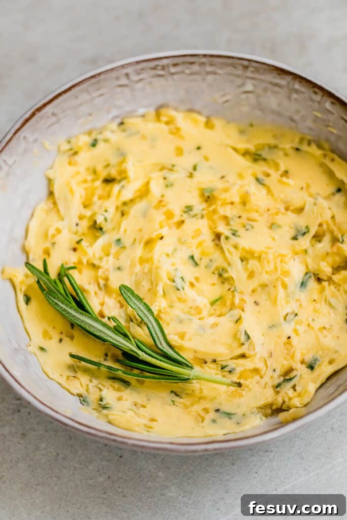 Close-up of a bowl containing softened butter mixed with fresh rosemary, ready for the turkey.