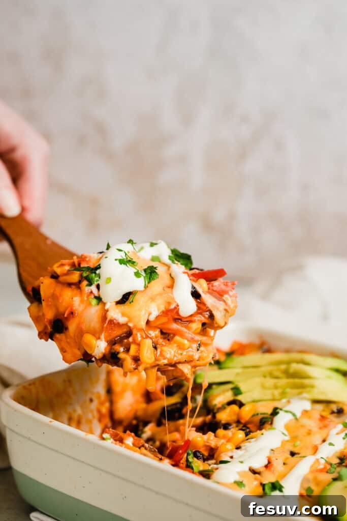 Cheesy Chicken Enchilada Delight 2 A serving of cheesy Chicken Enchilada Casserole on a large wooden scoop, ready to be enjoyed.