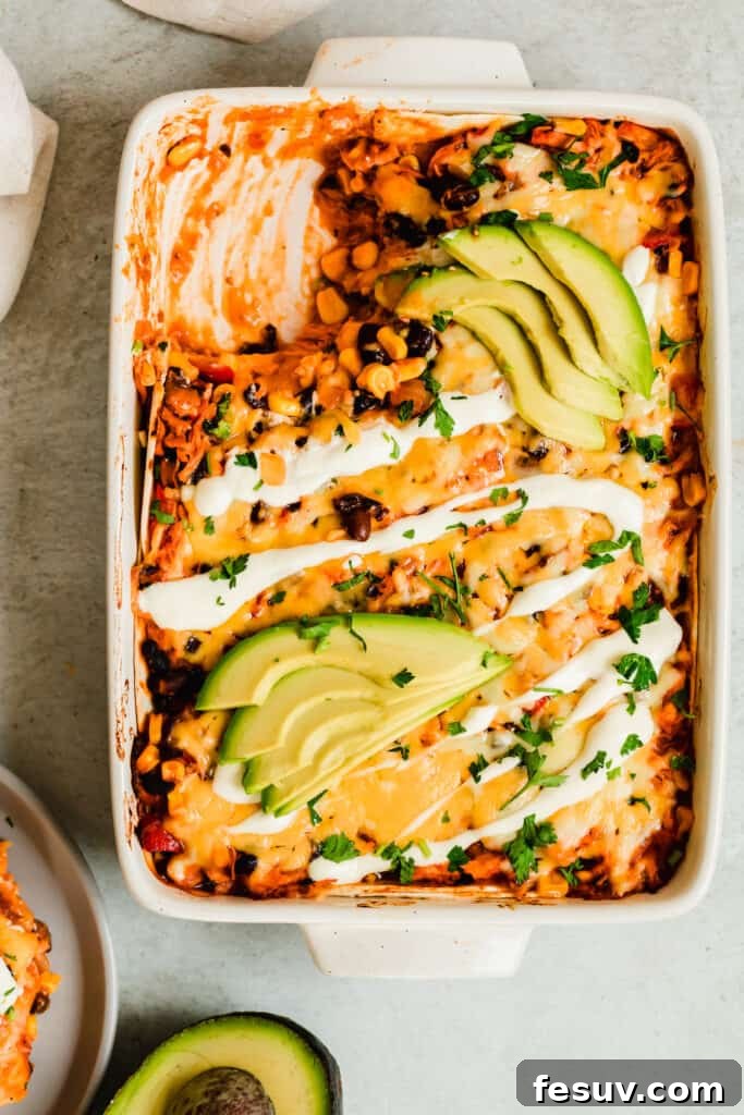 Cheesy Chicken Enchilada Delight 4 A vibrant Chicken Enchilada Casserole in a baking dish, accompanied by a halved avocado and a serving plate, inviting a delicious meal.