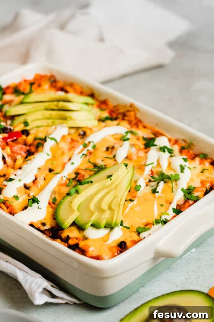 Cheesy Chicken Enchilada Delight 8 A beautifully baked Enchilada Casserole, artfully garnished with fresh sour cream and slices of creamy avocado, ready to be served.