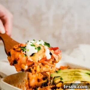 A Serving of Chicken Enchilada Casserole on a Large Wooden Scoop