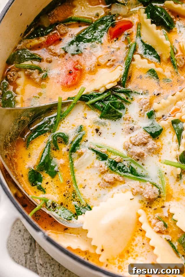Close up image of a soup with spinach and ravioli.