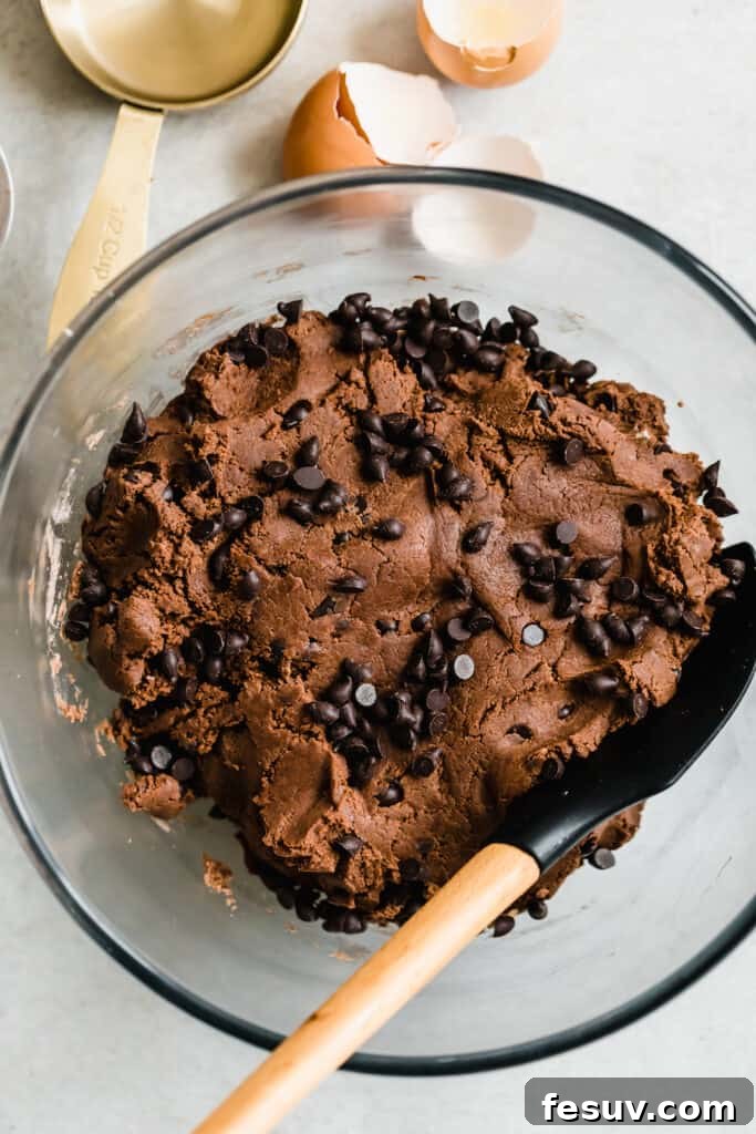 Hot Chocolate Sugar Cookie Dough with Mini Chocolate Chips and a Rubber Spatula in the Bowl