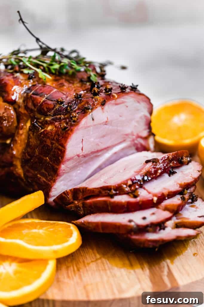 A Glazed Christmas Ham with Four Slices Cut Off, shimmering with a rich, caramelized brown sugar glaze.