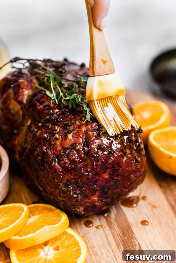 Topping the Cooked Christmas Ham with the Rest of the Glaze, showcasing the rich, golden-brown glaze being applied generously.