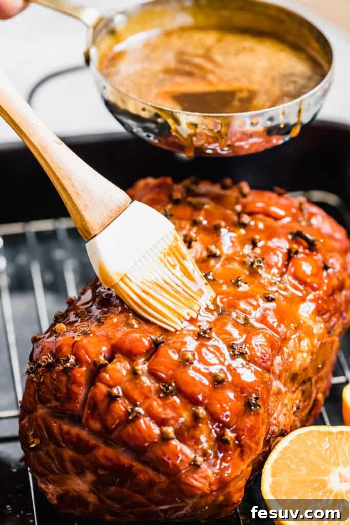 Pouring and Brushing Brown Sugar Glaze Over the Ham, creating a beautiful, glossy coating.