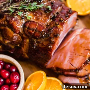 Slices of Christmas Ham on a Circular Wooden Surface with Assorted Fruits