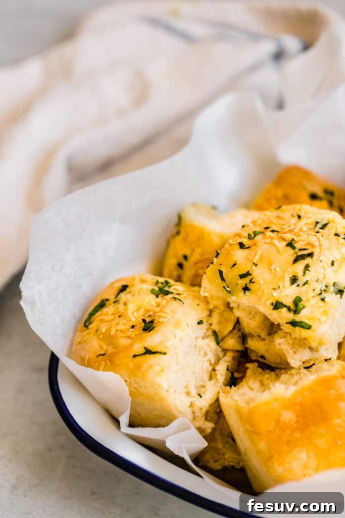 Warm Parmesan Dinner Rolls neatly arranged in a rustic serving dish, ready for the table