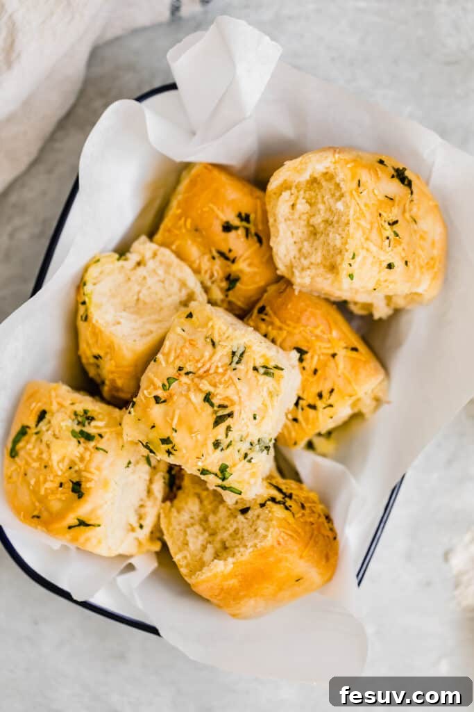 Seven Soft Parmesan Dinner Rolls nestled in a charming woven basket lined with white tissue paper