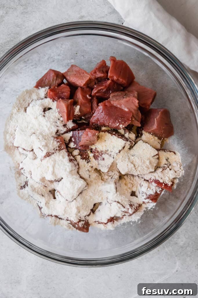 Effortless Creamy Instant Pot Beef Stroganoff 6 A Glass Bowl Holding the Beef and Flour Mixture, ready for cooking.