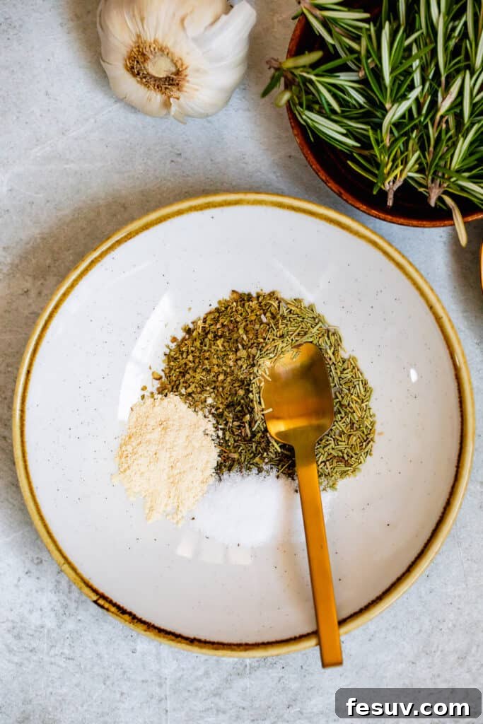 Assorted seasoning herbs, including oregano, thyme, rosemary, garlic powder, salt, and pepper, in a small gold-trimmed plate.
