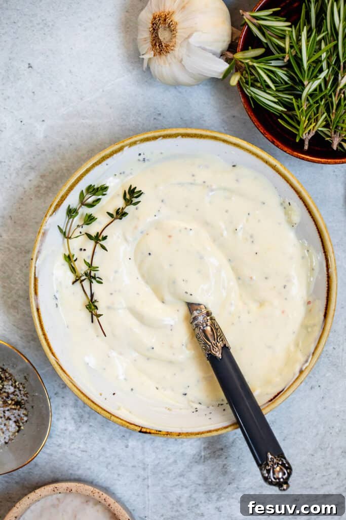 A elegant bowl of homemade creamy horseradish sauce with a small, decorative spoon inside, ready to serve.