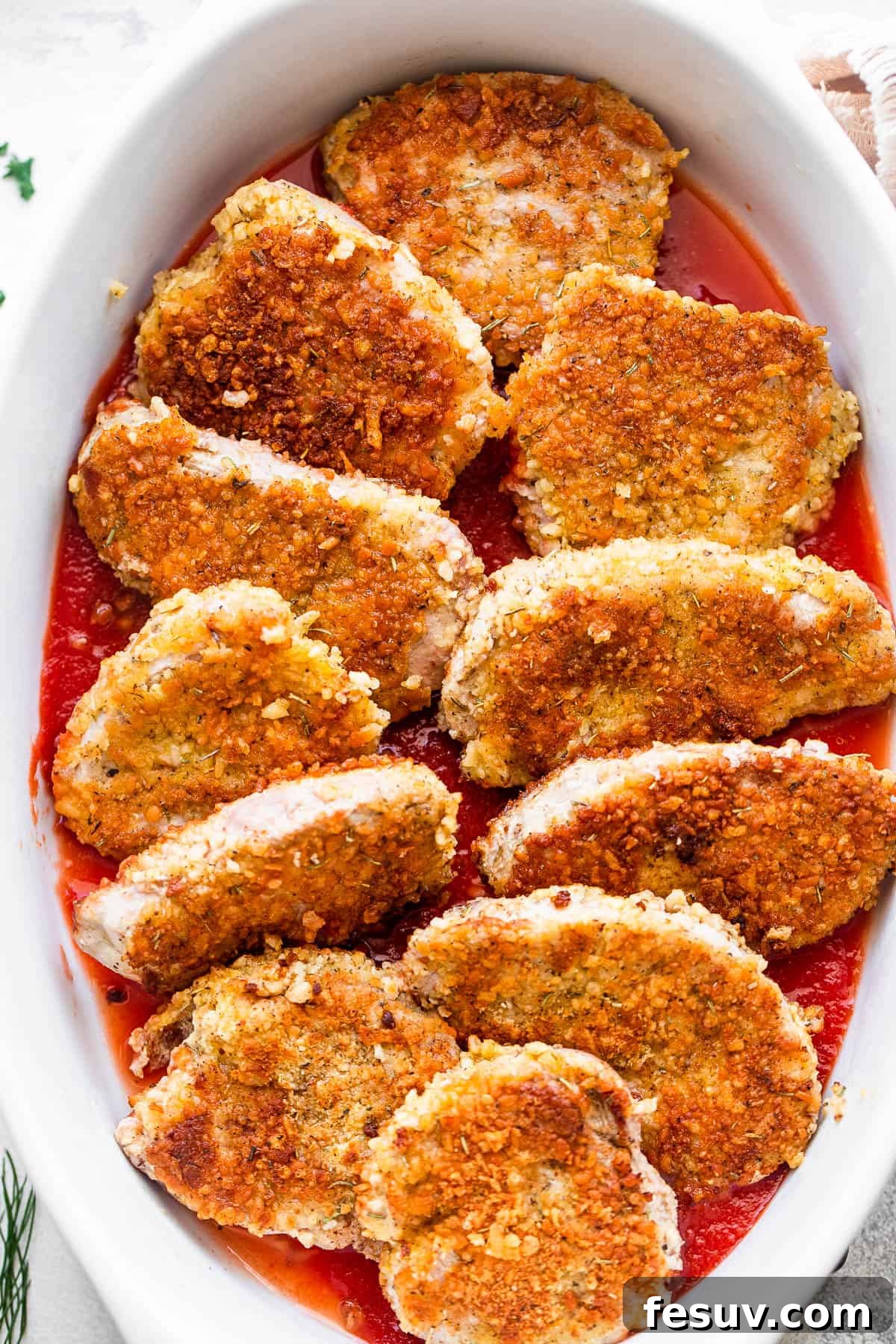 Crispy Pork Parmesan 4 breaded pork medallions arranged in a white baking dish