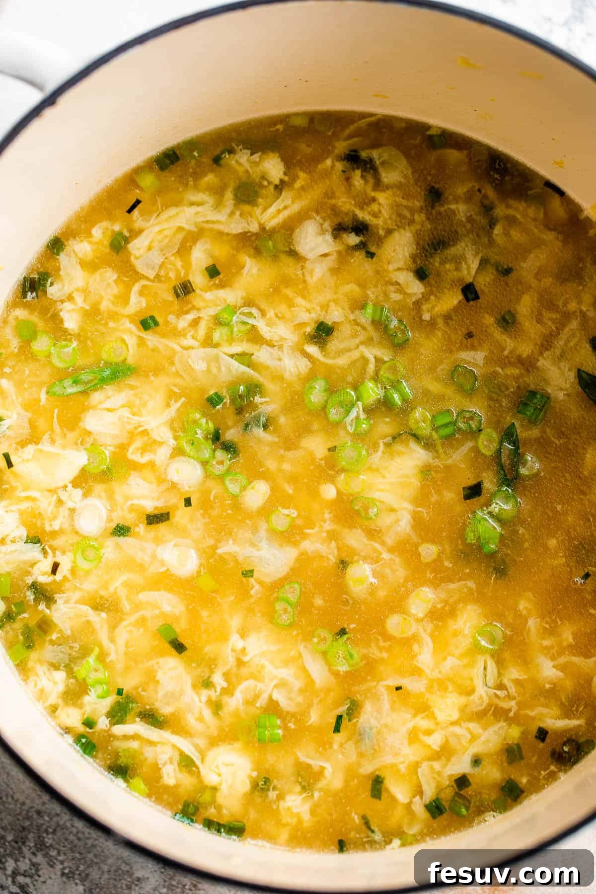 Egg Drop Soup Cooking in a Pot Egg drop soup simmering in a large Dutch oven, showing the beautiful egg ribbons forming.