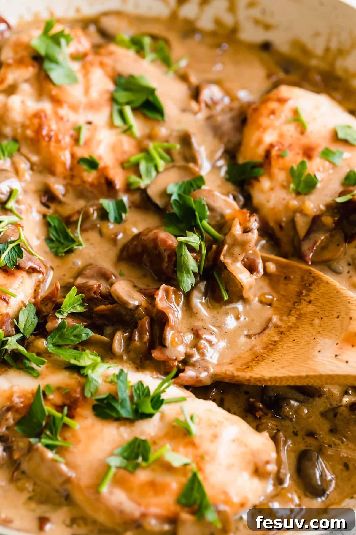Rich Creamy Chicken Marsala 5 Close up of mushrooms cooking in a creamy marsala sauce with fresh herbs sprinkled on top.