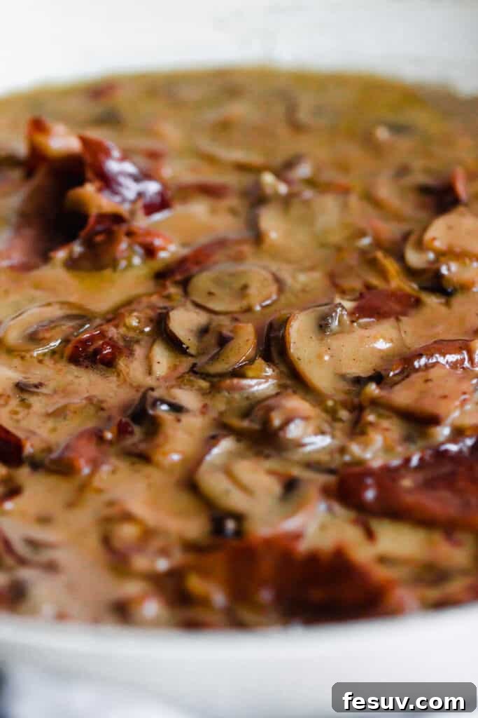 Rich Creamy Chicken Marsala 7 Mushrooms and proscuitto cooking in a creamy sauce.