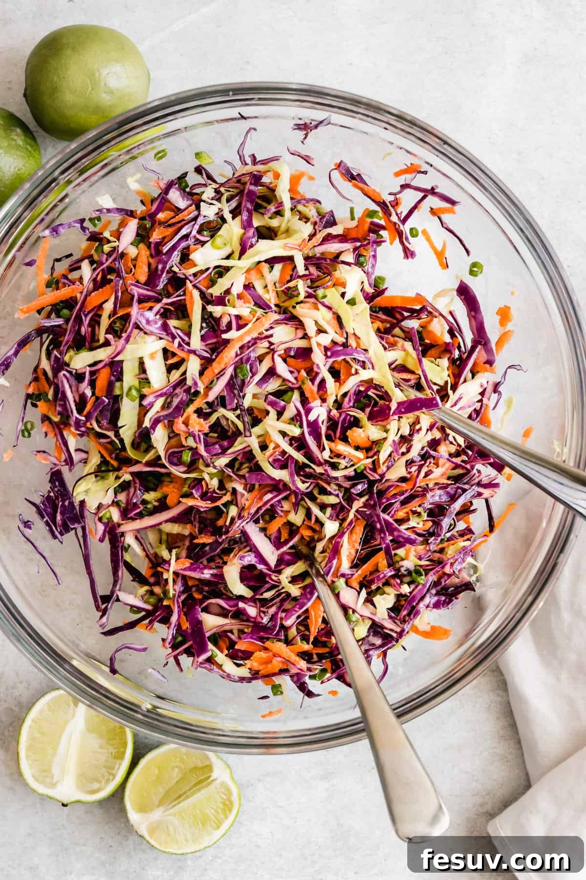 My easy shrimp tacos recipe with Asian cabbage slaw is guaranteed to be a new favorite. The classic flavors of a warm shrimp taco blend amazingly with the fresh, crunchy slaw in warm tortillas! The Completed Asian Cabbage Slaw in a Large Glass Bowl