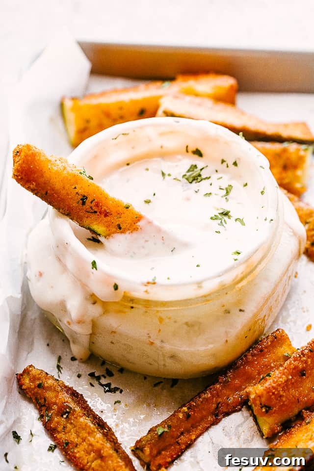 These air fryer zucchini fries are super crispy on the outside, tender on the inside, and perfect for dipping. Your go-to summer side dish! Zucchini fries dipped in a delicious sauce.