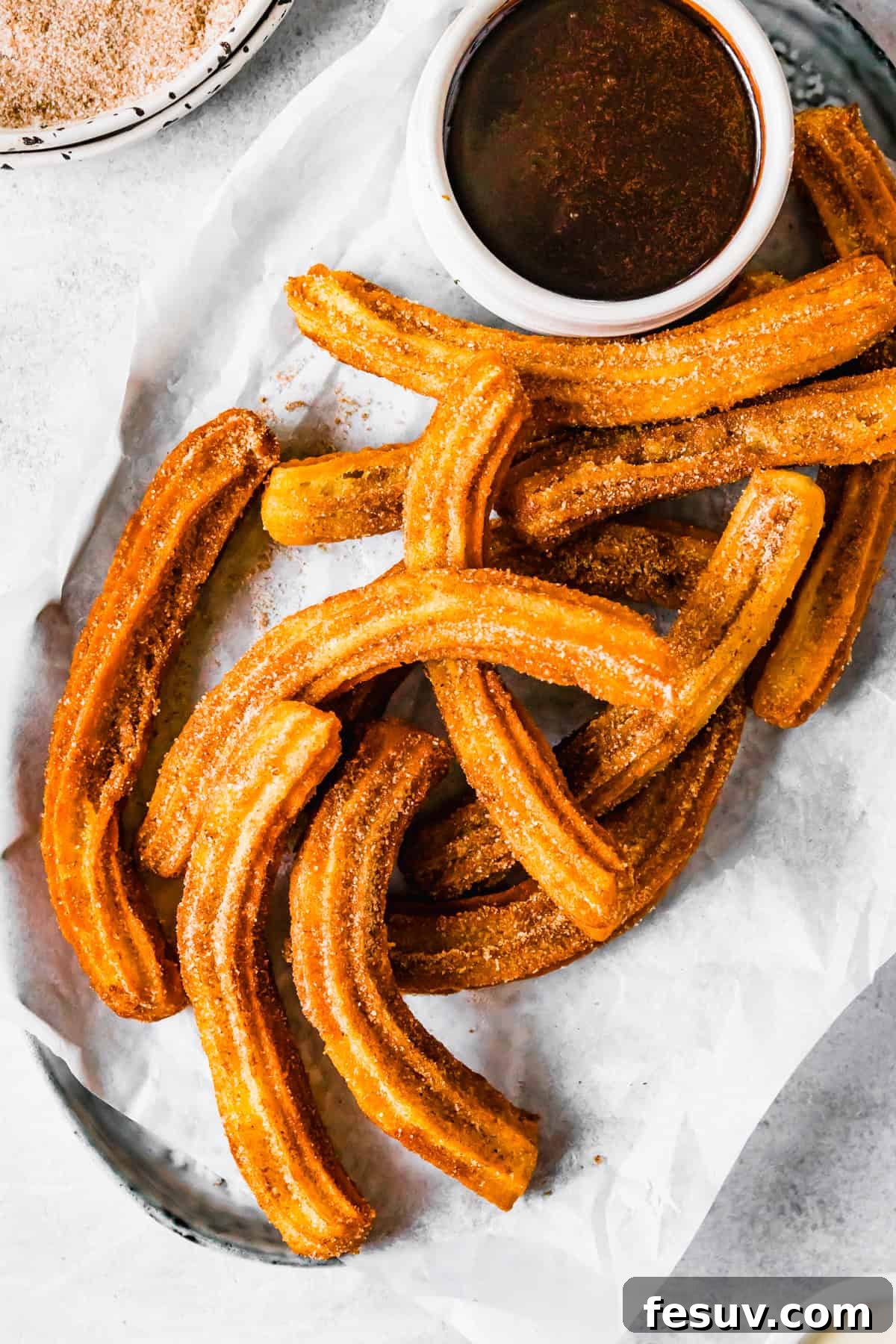 Perfect Homemade Churros 2 Freshly made churros served on a plate with a side bowl of chocolate dipping sauce, ready to be enjoyed.
