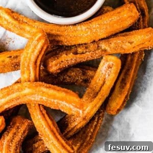 Perfect Homemade Churros 11 Churros recipe by easy weeknight recipes. The churros are served on a plate with a bowl of chocolate sauce.
