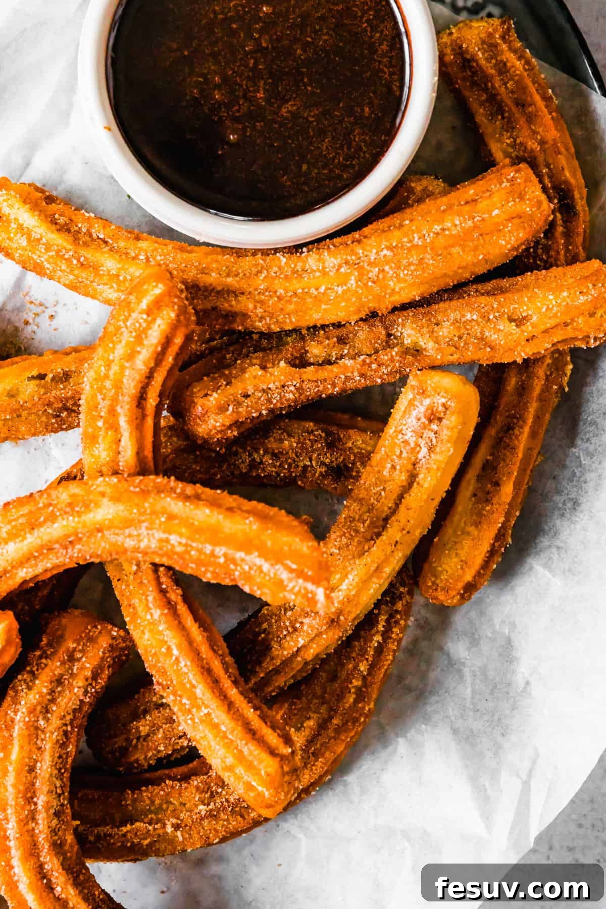 Perfect Homemade Churros 10 A vibrant plate of homemade churros with a bowl of chocolate dipping sauce, ready to be served.