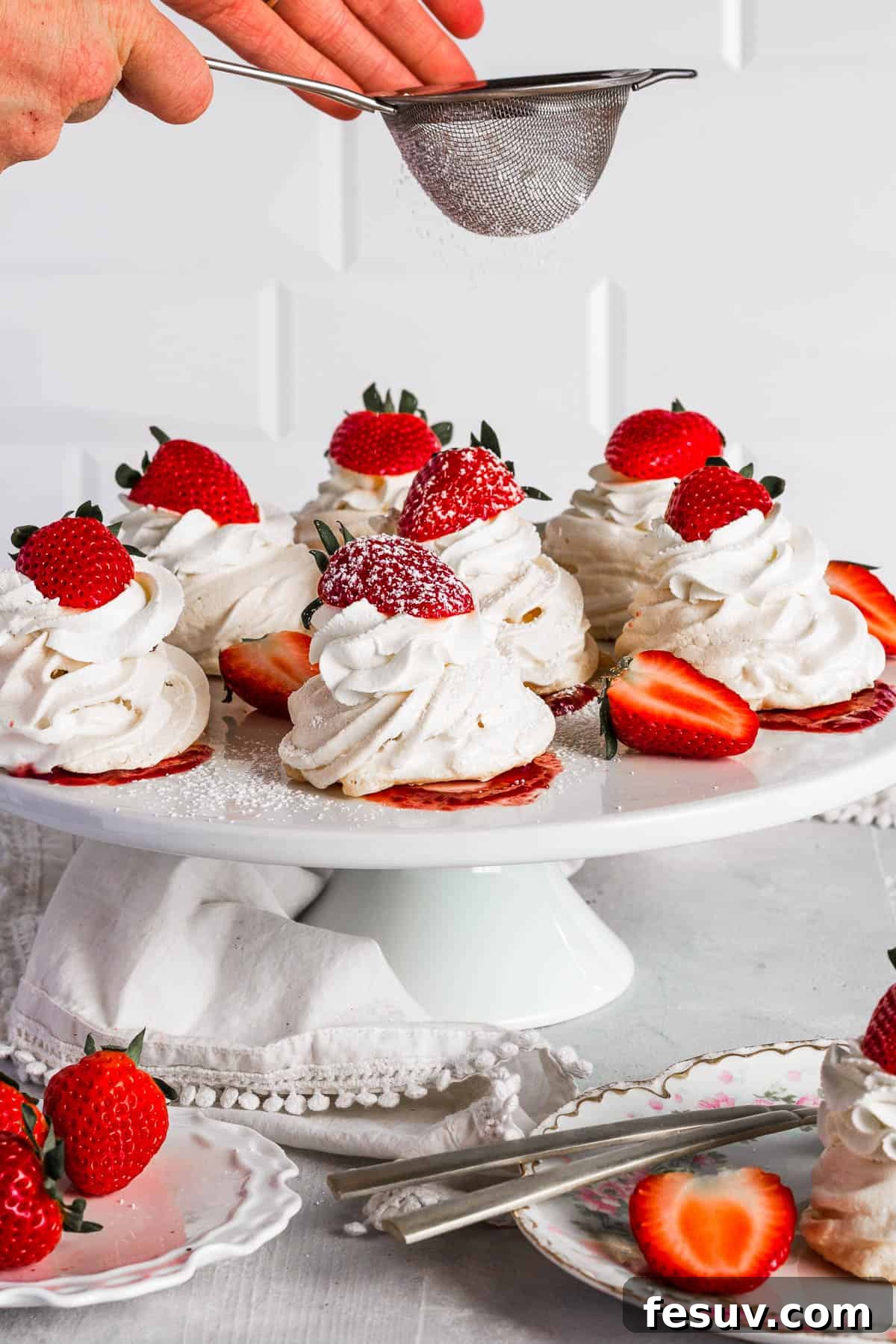 Sifting confectioners sugar onto pavlovas