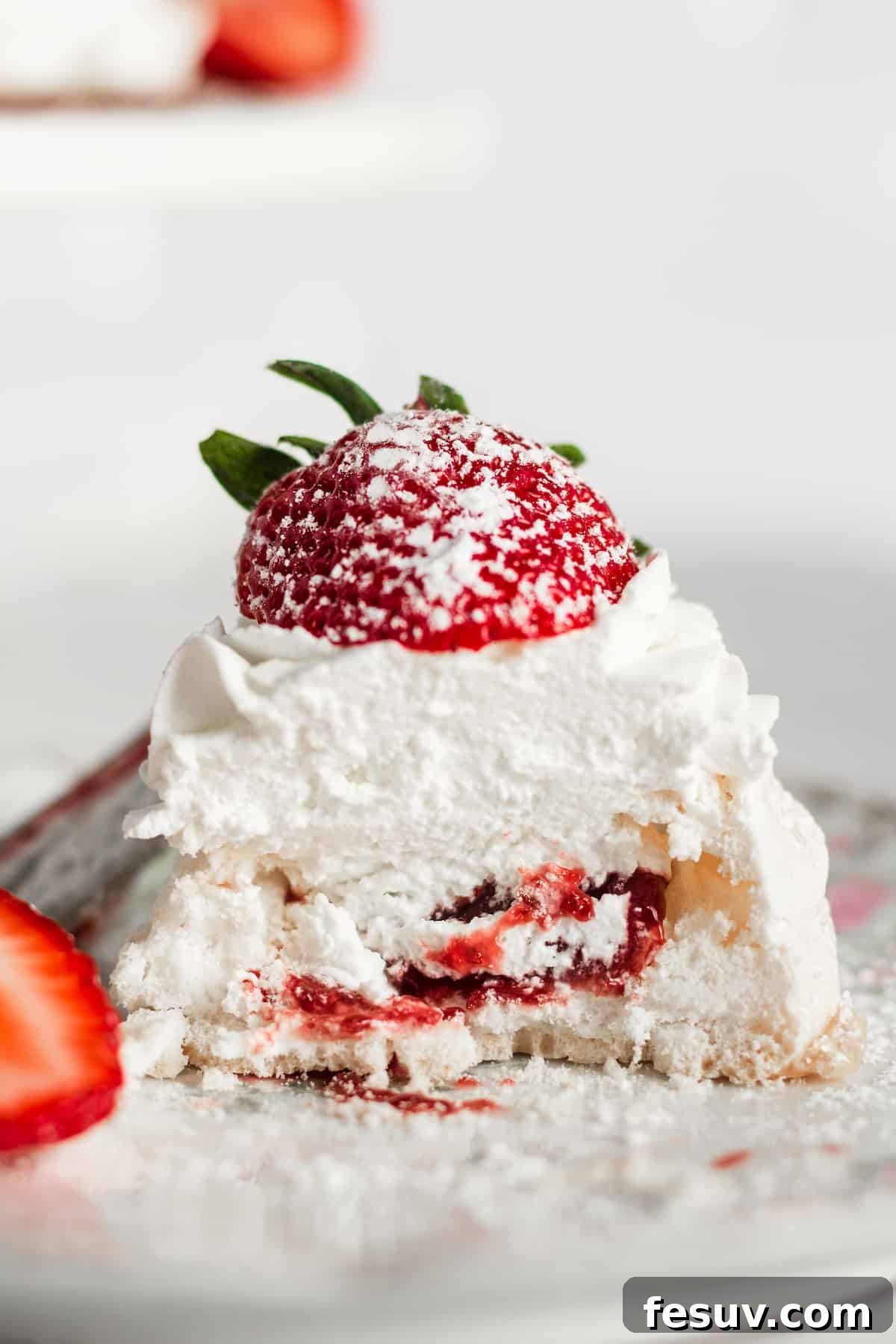 The inside of a pavlova with strawberry jam