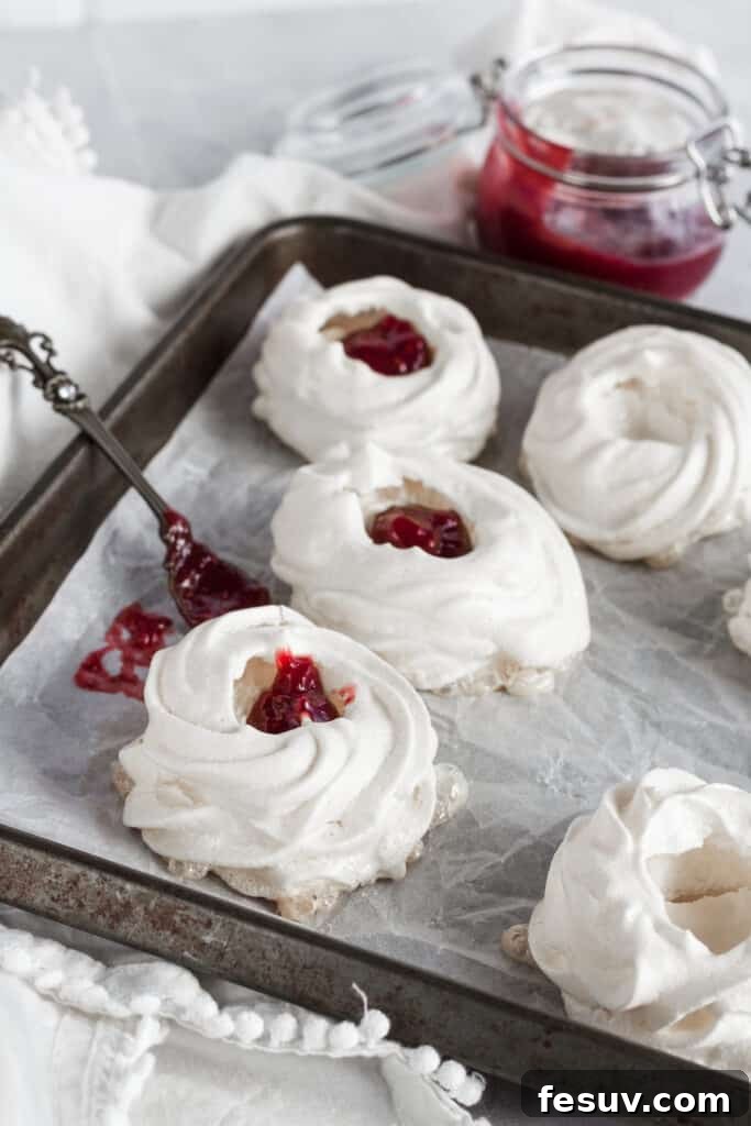 Pavlova nests being filled with strawberry filling