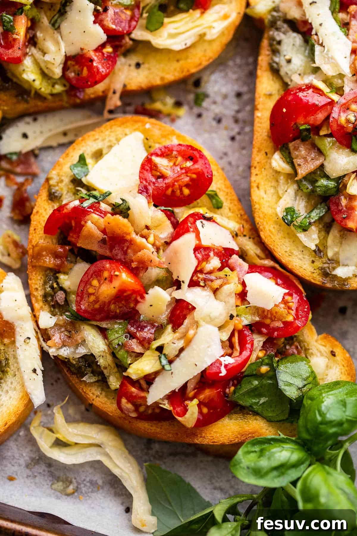 Close-up shot of individual BLT Bruschetta slices on a serving board, highlighting the fresh toppings and crispy bread
