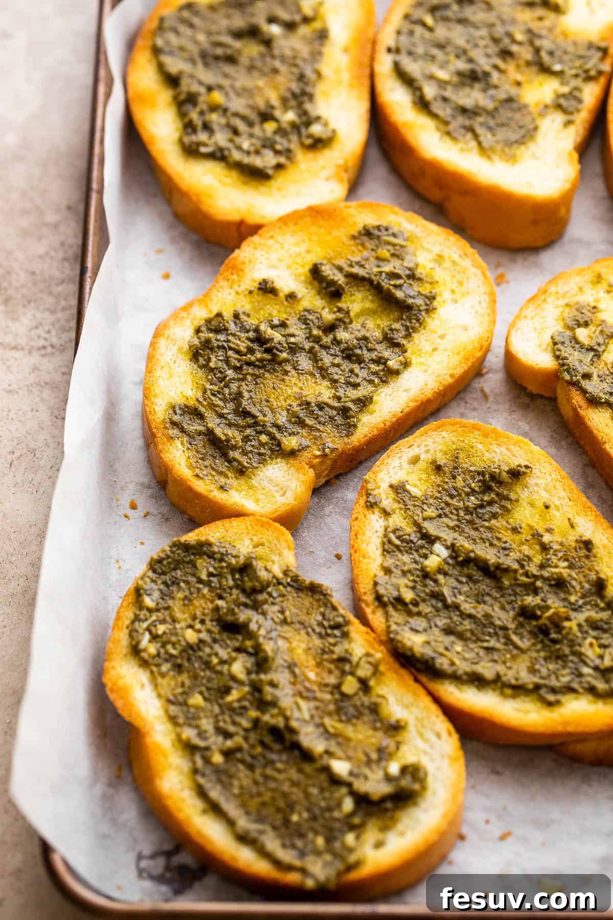 toasted bread slices topped with vibrant green basil pesto, ready for the BLT topping