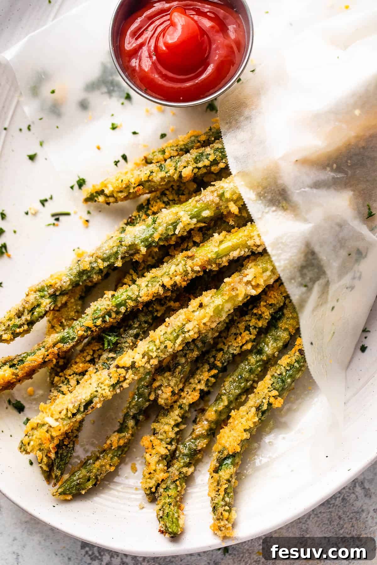 overhead shot of baked parmesan panko asparagus fries served with ketchup on the side