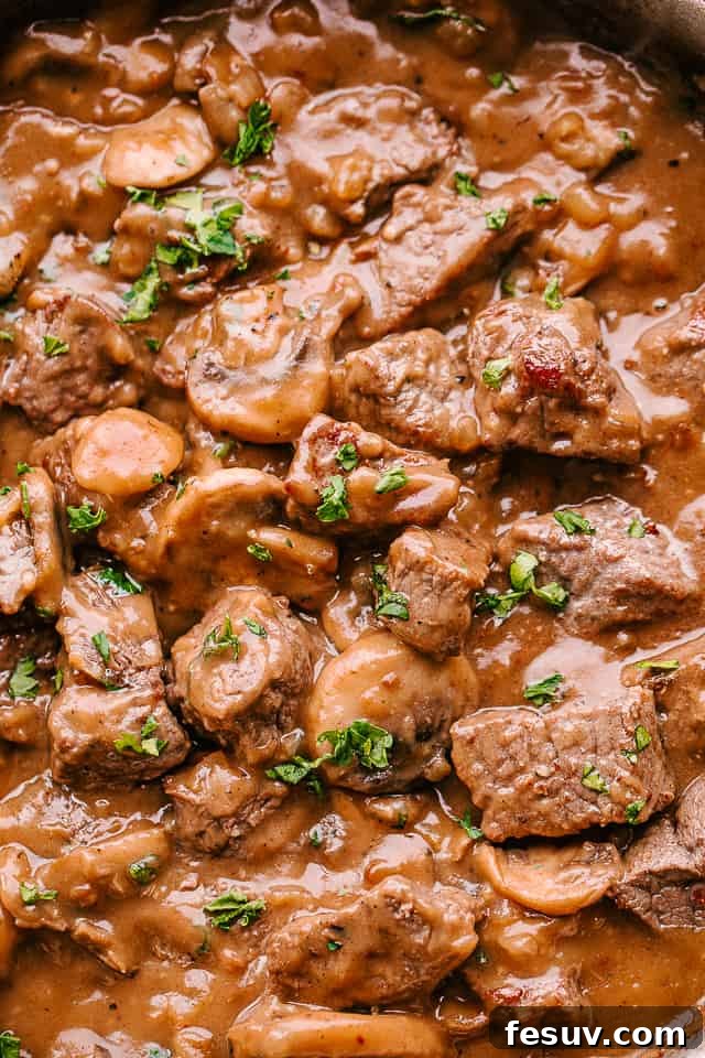 A cozy dinner scene with a bowl of beef tips in mushroom gravy, ready to be enjoyed.